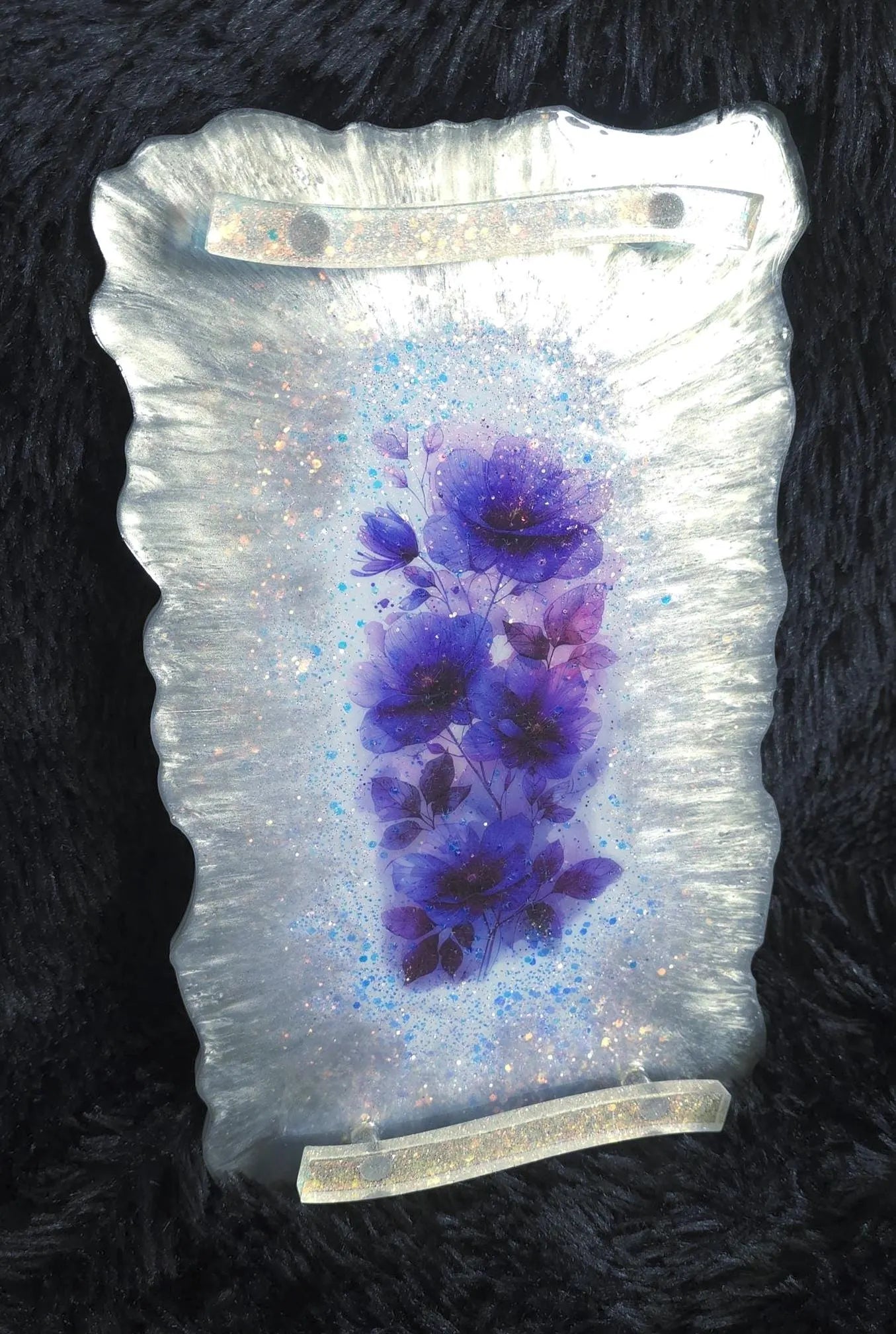 Decorative resin piece with blue floral design on a white textured background
