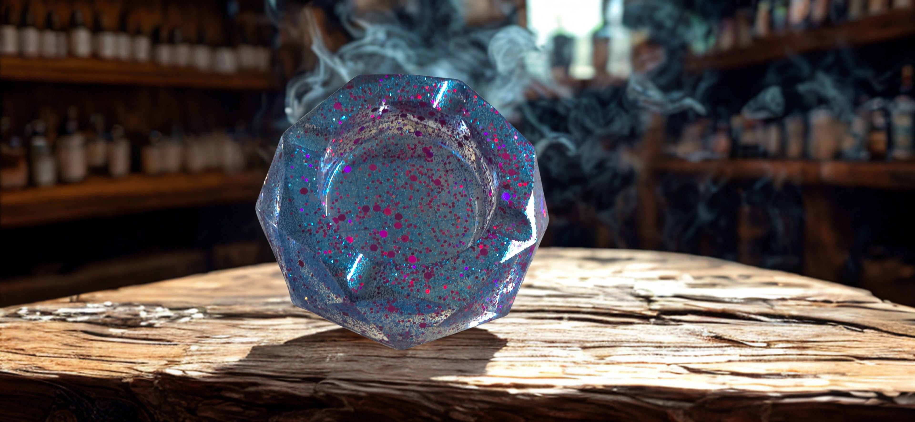 Iridescent resin ash tray on a wooden surface with bottles in the background