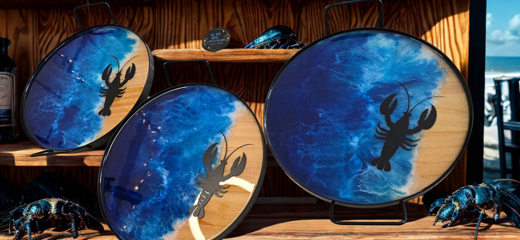 Three blue drums with lobster silhouettes on a wooden surface.